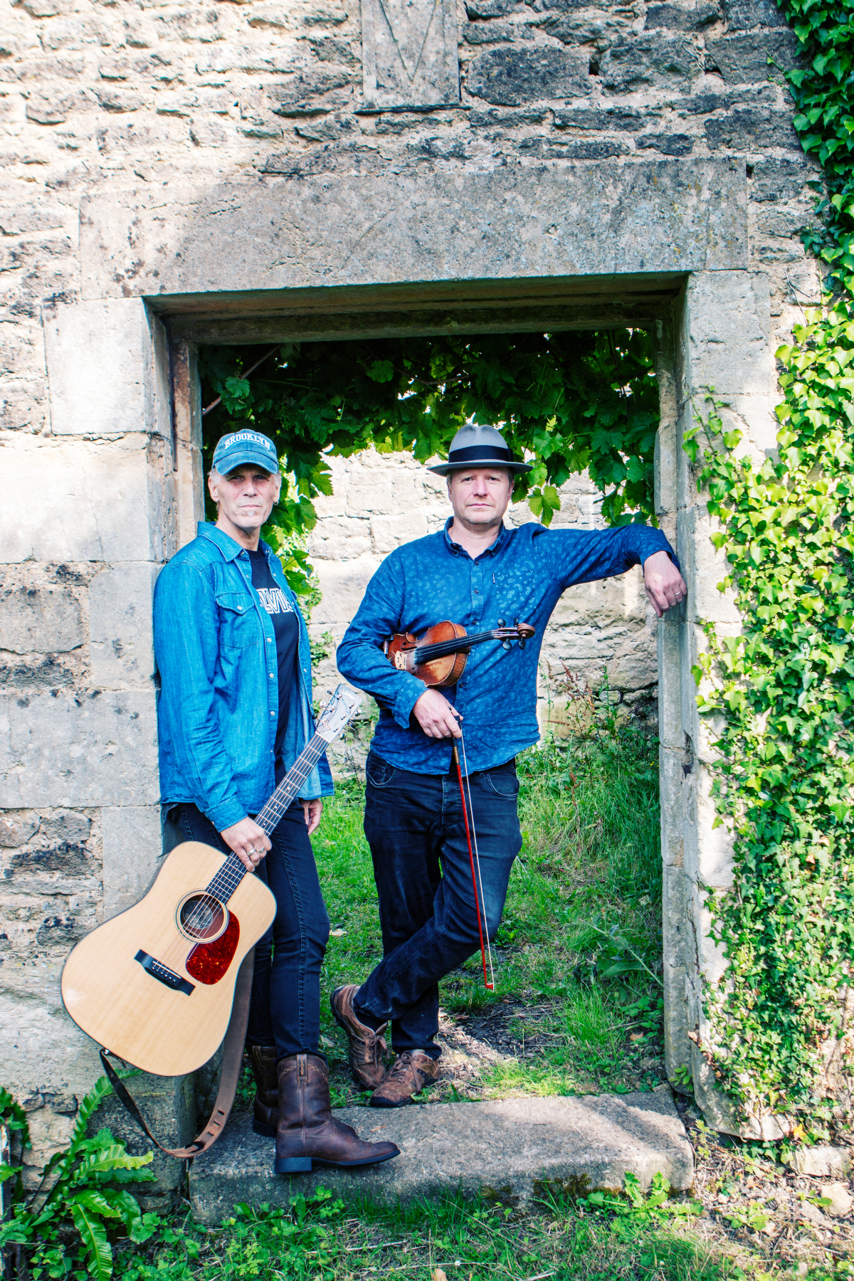 Brooks Williams and Aaron Catlow standing in a stone archway