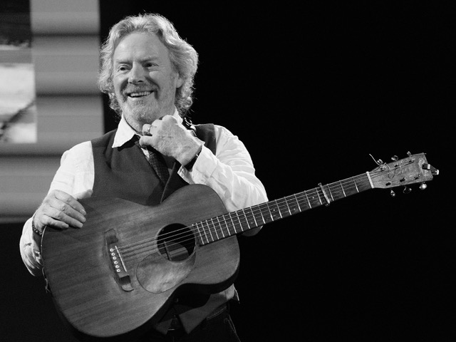 Black and white picture of Reg Meuross smiling on stage